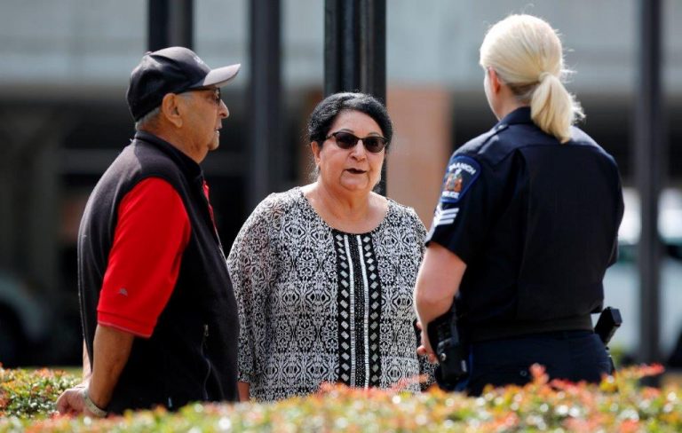 photo showing a female police officer speaking to two individuals